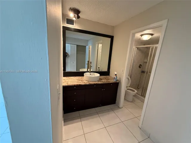 a spacious bathroom with a granite countertop sink and a mirror