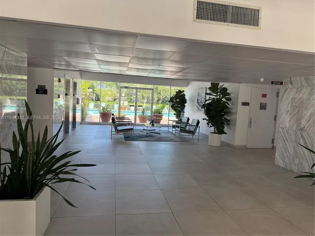 a lobby with furniture and potted plants