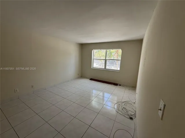 an empty room with closet and mirror