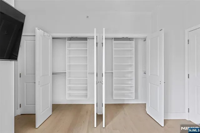 a view of walk in closet with empty racks