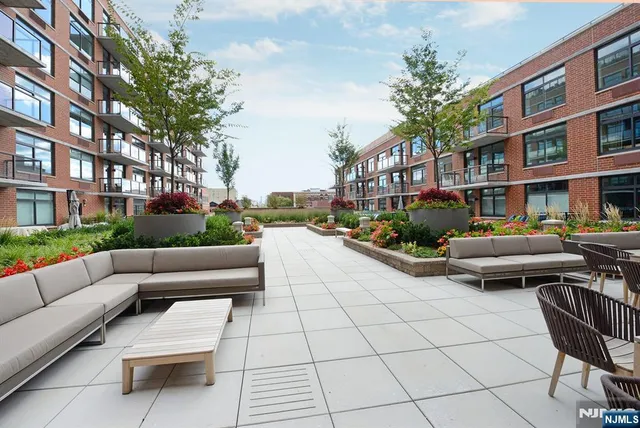 a view of a patio with couches and a fire pit and wooden fence