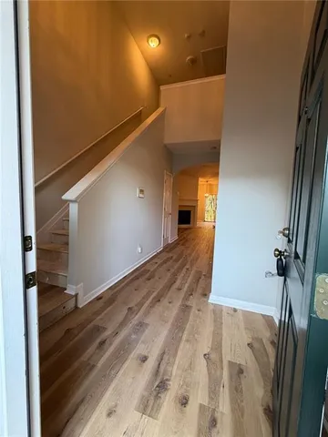 a view of a hallway with wooden floor and staircase