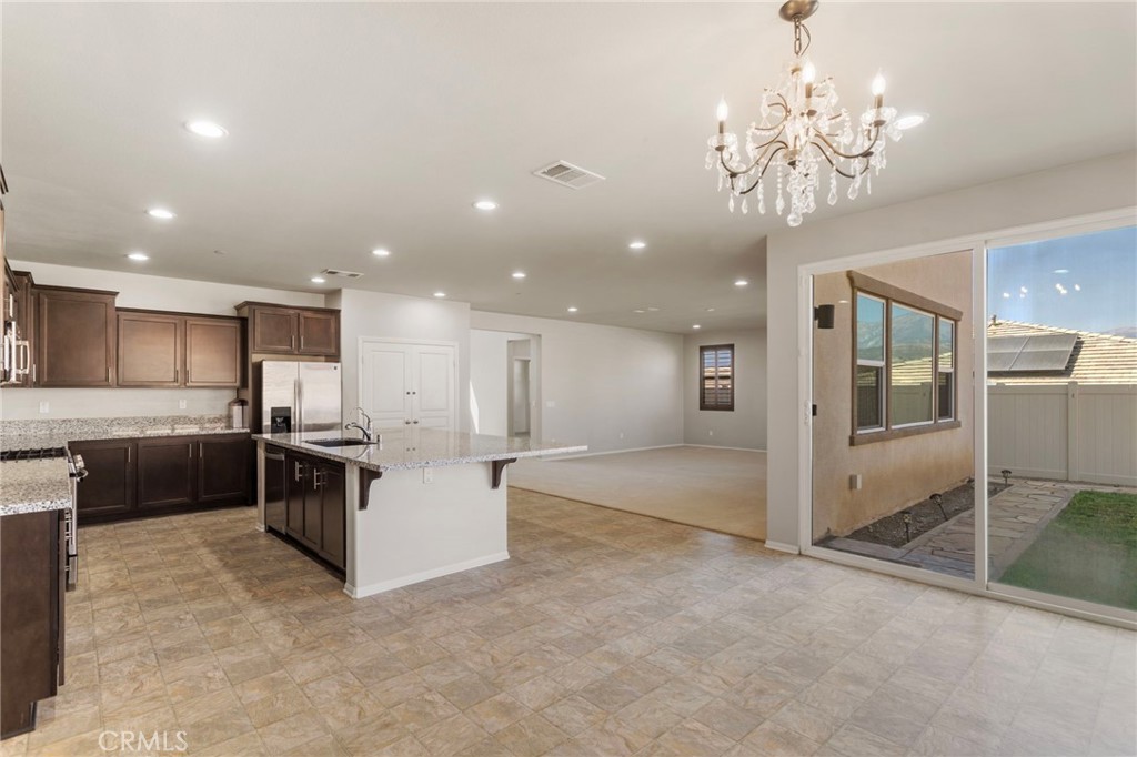 11462 Jacobsen Road Beaumont, CA 92223 - Photo 12 of 45 a large white kitchen with a large counter top appliances and cabinets