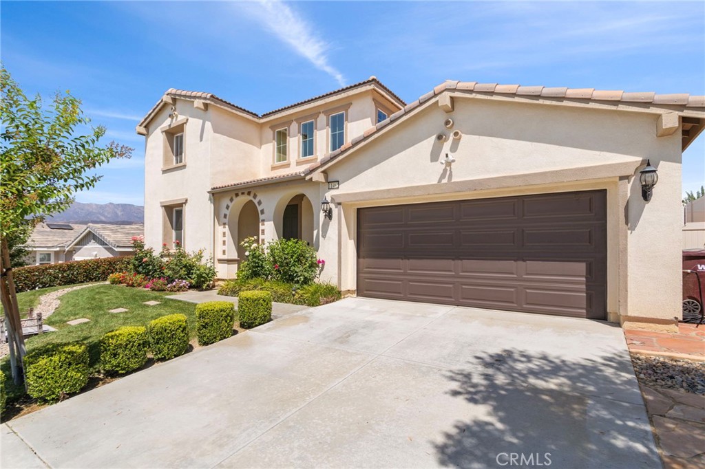 11462 Jacobsen Road Beaumont, CA 92223 - Photo 2 of 45 a front view of a house with a yard and garage