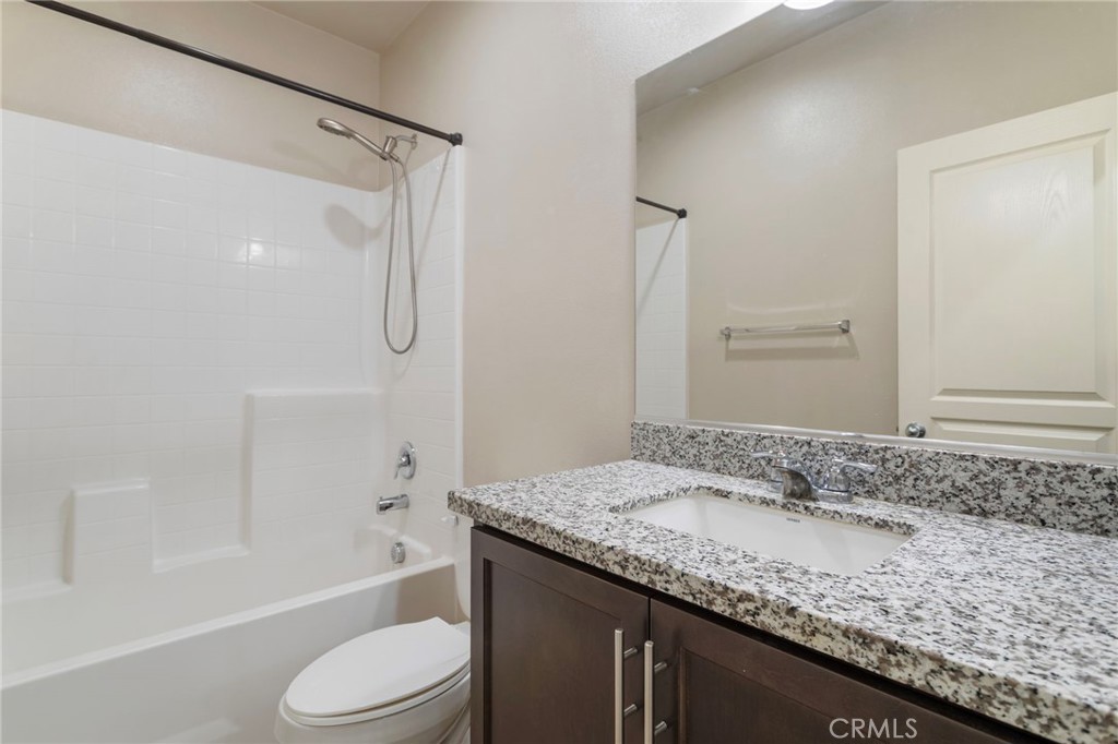 11462 Jacobsen Road Beaumont, CA 92223 - Photo 29 of 45 a bathroom with a granite countertop sink toilet and shower
