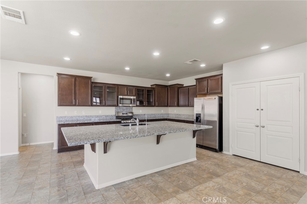11462 Jacobsen Road Beaumont, CA 92223 - Photo 8 of 45 a large kitchen with stainless steel appliances lots of white cabinets
