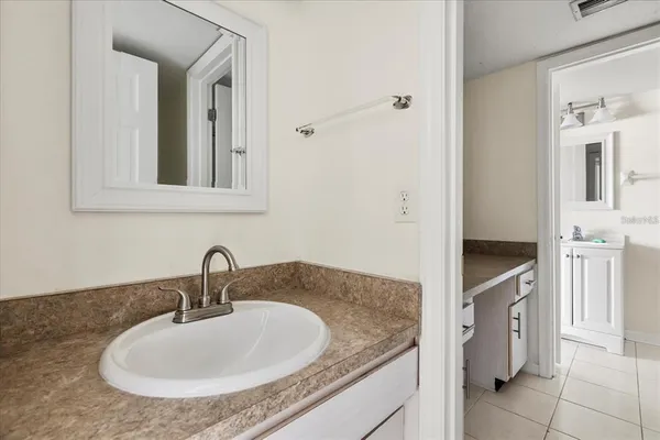 a bathroom with a granite countertop sink and a mirror
