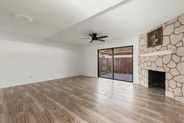 a view of an empty room with a fireplace and a window