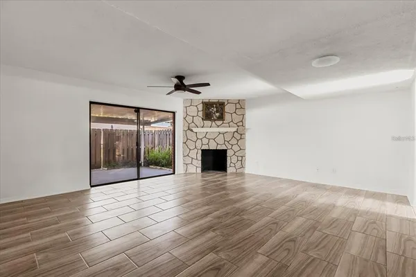 a view of a livingroom with wooden floor and a fireplace