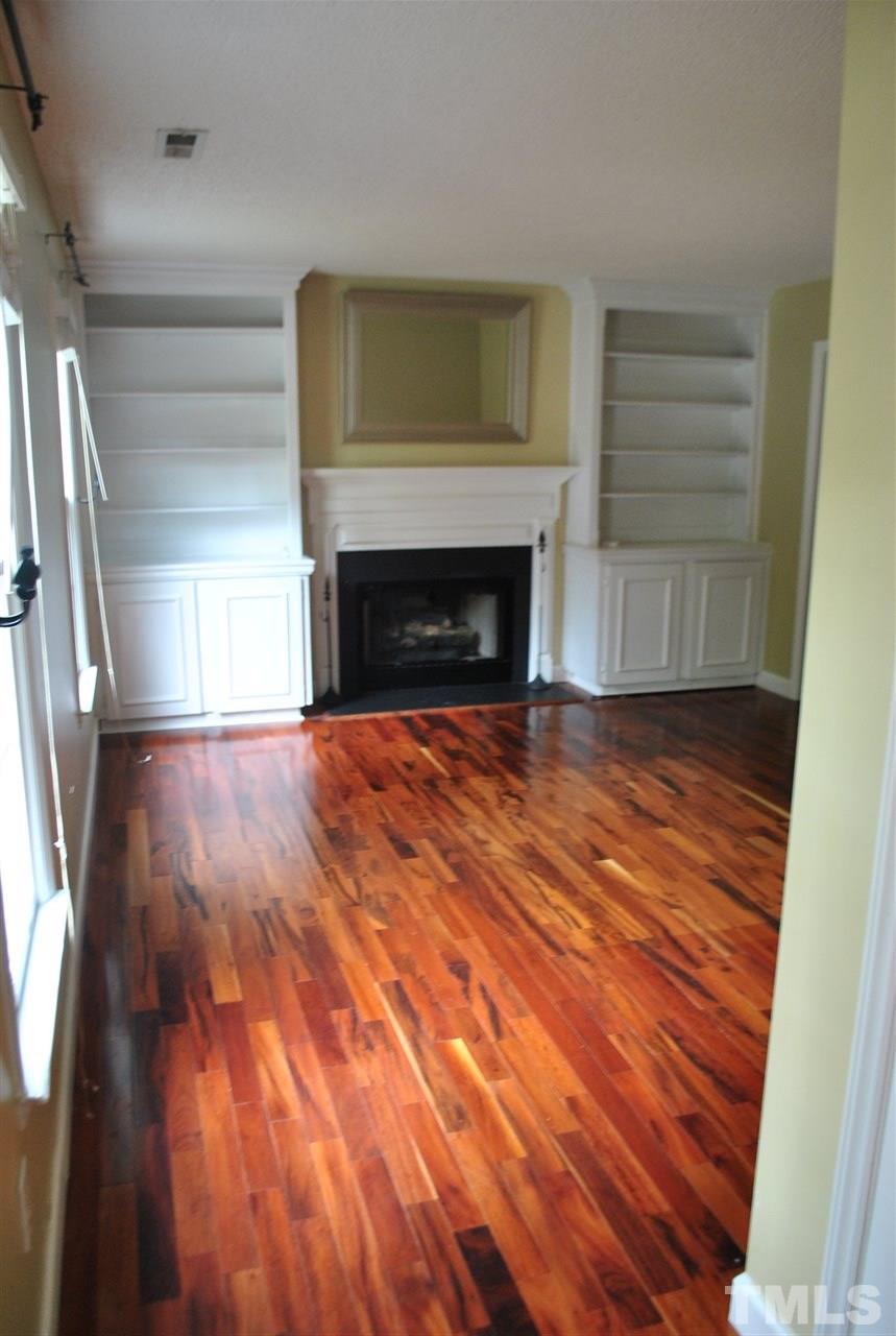 3424 Ribcowski Court Raleigh, NC 27616 - Photo 3 of 20 a view of empty room with wooden floor and fireplace