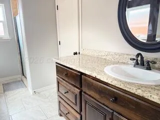 a bathroom with a granite countertop sink and a mirror