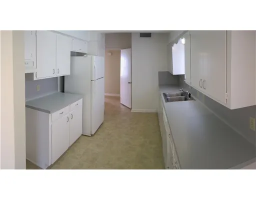 a open kitchen with a sink and refrigerator