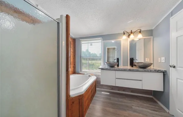 a bathroom with a tub sink and mirror