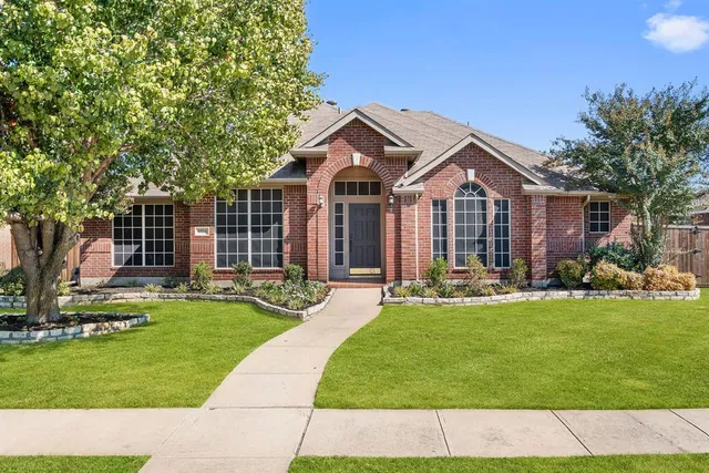 a front view of a house with a garden and patio