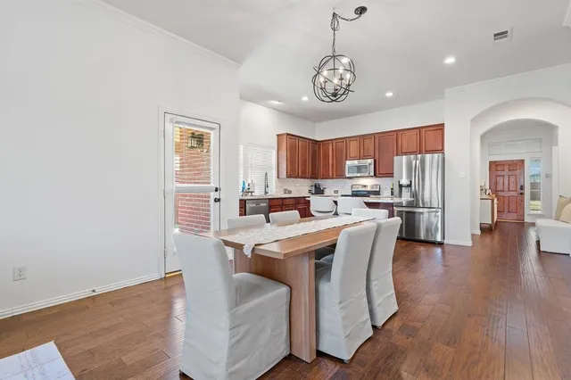a view of a dining room with furniture a chandelier and wooden floor
