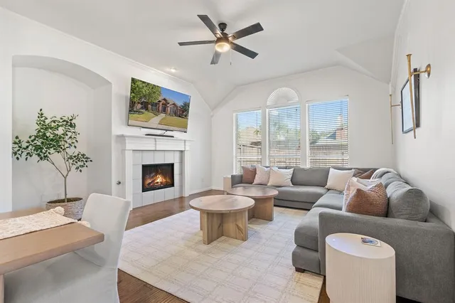 a living room with furniture a large window and a fireplace