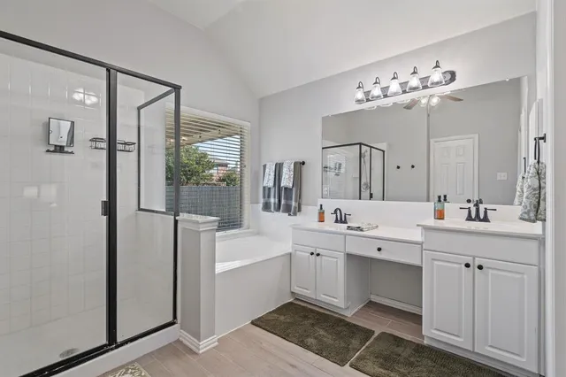 a large bathroom with a double vanity sink a mirror and a bathtub