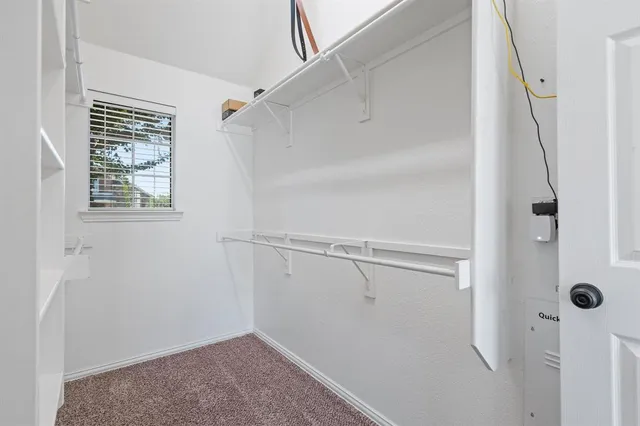 a view of closet area with racks on the wall