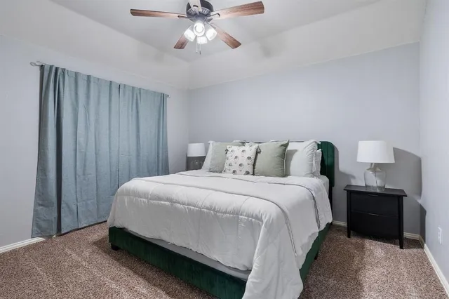 a spacious bedroom with a bed and a chandelier