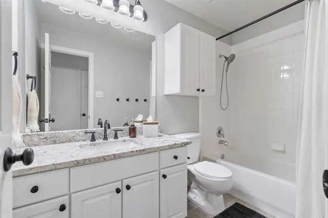 a bathroom with a granite countertop sink a toilet and a mirror