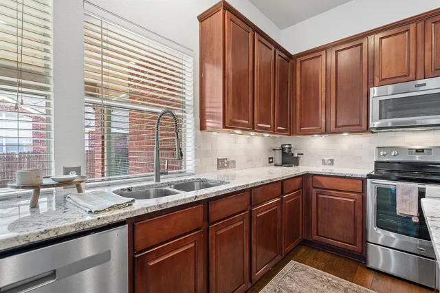 a kitchen with stainless steel appliances granite countertop a sink stove and cabinets