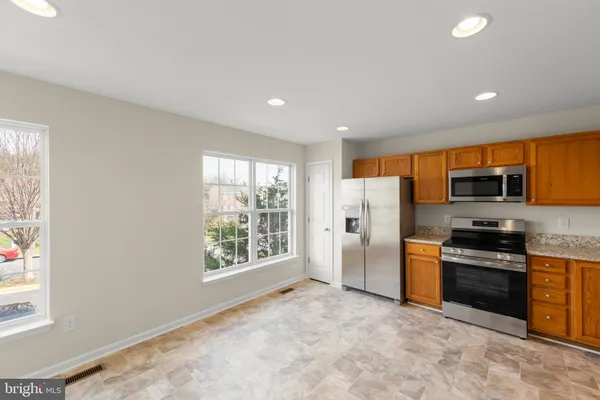 a view of a kitchen with stainless steel appliances wooden cabinets and a window