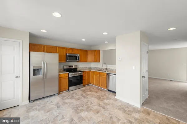 a kitchen with stainless steel appliances granite countertop a refrigerator and a sink
