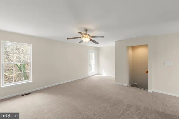 a view of a livingroom with a ceiling fan and window