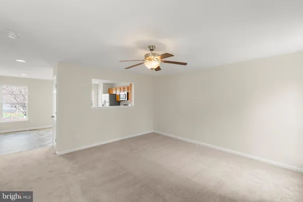 an empty room with fan and windows