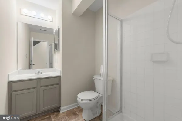 a bathroom with a toilet sink vanity and mirror