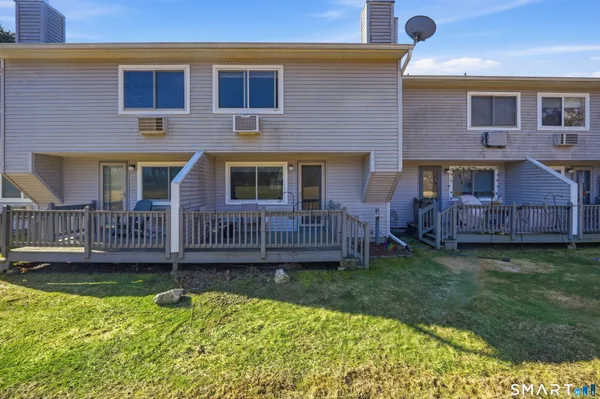 a view of a house with a yard and a wooden deck