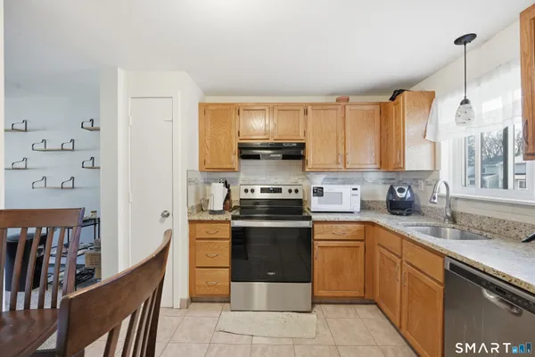a kitchen with stainless steel appliances granite countertop a stove a sink dishwasher and a refrigerator