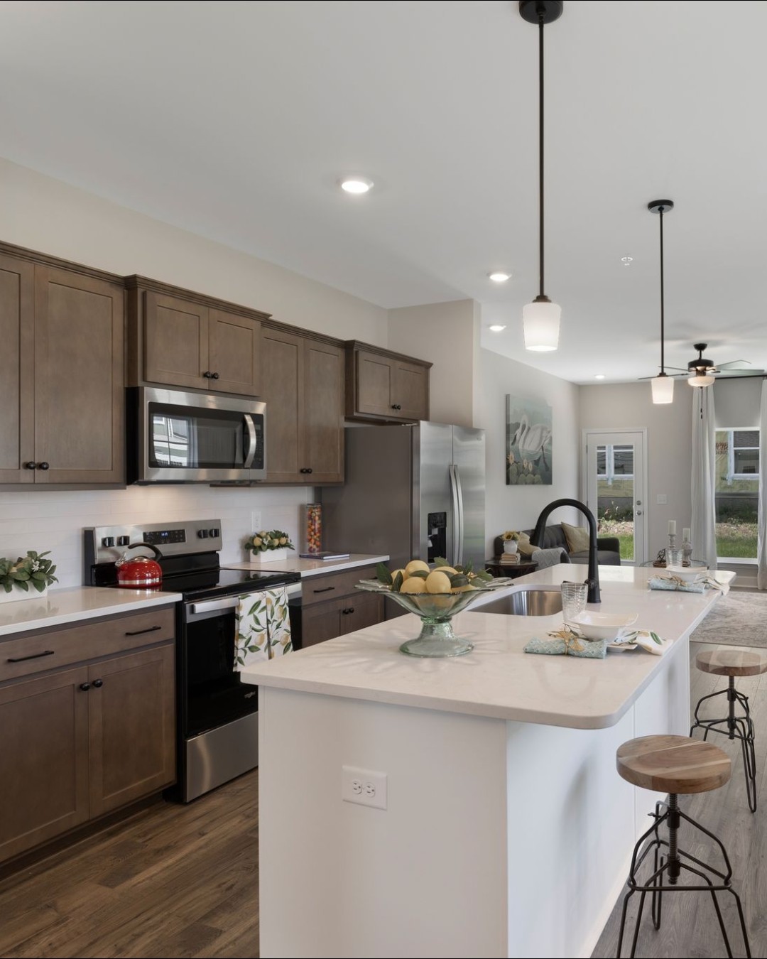 1120 June Wilde Ridge Spring Hill, TN 37174 - Photo 2 of 15 a kitchen with a sink a stove and chairs with wooden floor