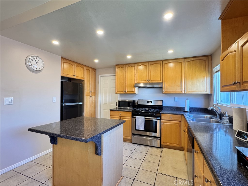 2065 Morley Street Simi Valley, CA 93065 - Photo 4 of 13 a kitchen with stainless steel appliances granite countertop a sink stove microwave and refrigerator