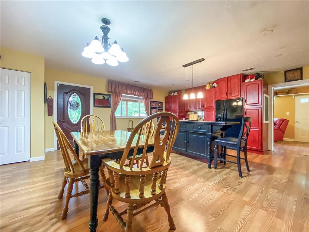 2022 Ridge Rd Extension Ambridge, PA 15003 - Photo 3 of 22 a dining room with furniture a chandelier and wooden floor