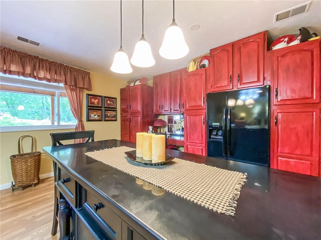 2022 Ridge Rd Extension Ambridge, PA 15003 - Photo 6 of 22 a kitchen with stainless steel appliances granite countertop a sink dishwasher and a open refrigerator with wooden floor