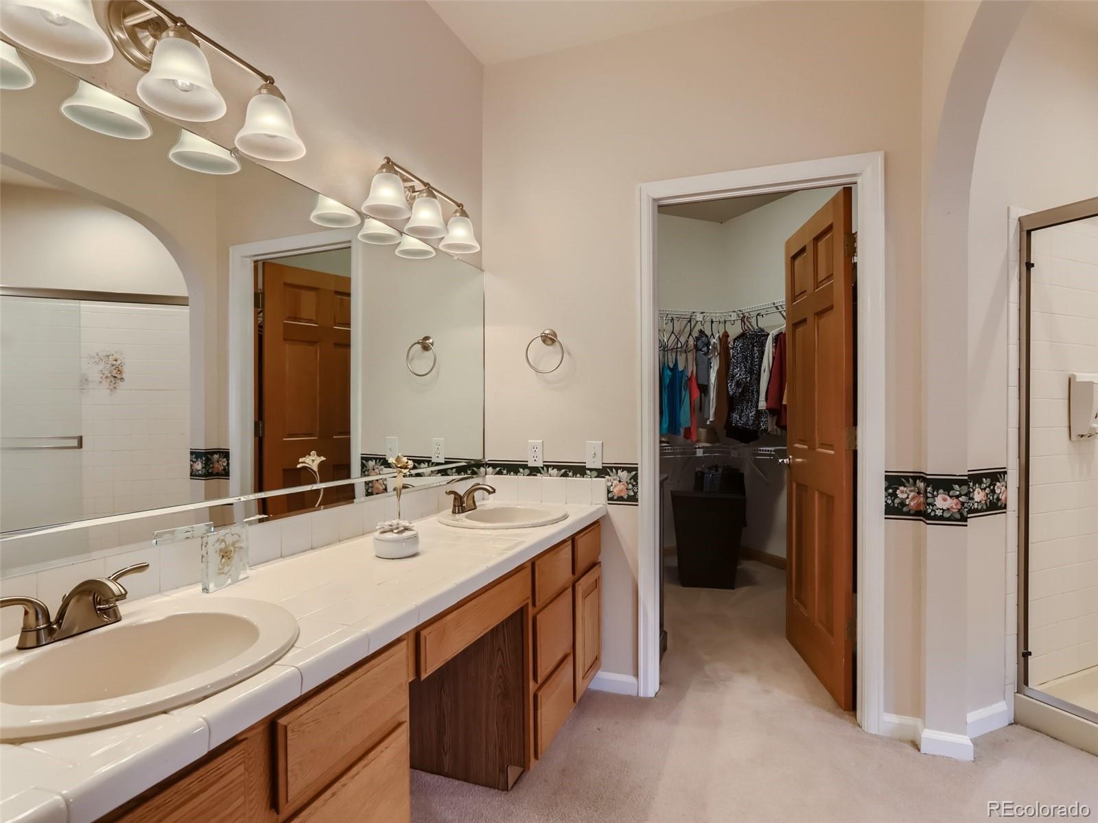 6370 Eagle Court Longmont, CO 80503 - Photo 15 of 39 a en suite bathroom with a double vanity sink and a mirror