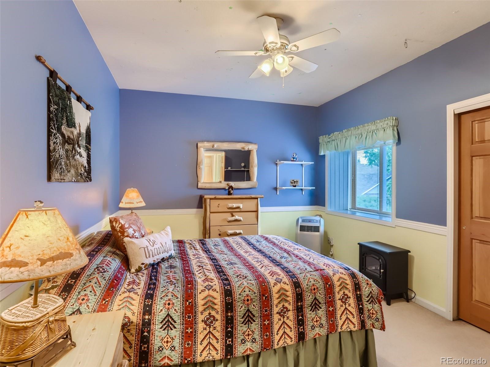 6370 Eagle Court Longmont, CO 80503 - Photo 19 of 39 a bedroom with a bed and a chandelier