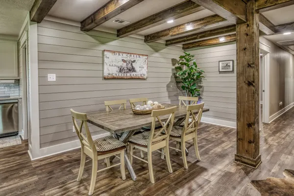 a patio with table and chairs and potted plants