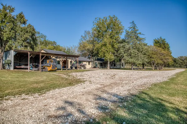 a view of a house with backyard and a tree