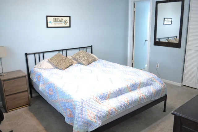 a large bed sitting in a bedroom next to a lamp