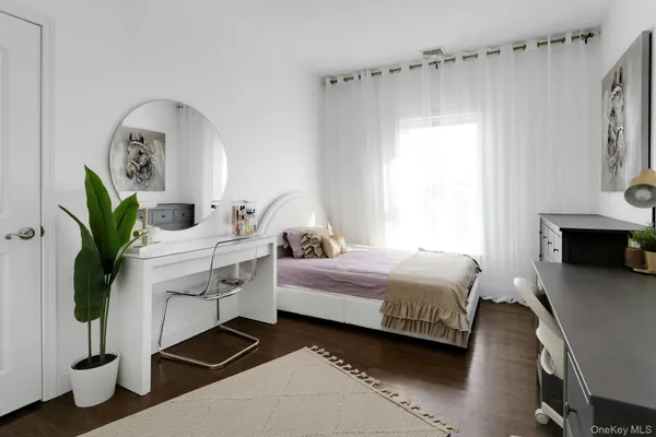 a bedroom with a bed table closet and a window