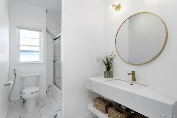 a bathroom with a sink mirror and toilet