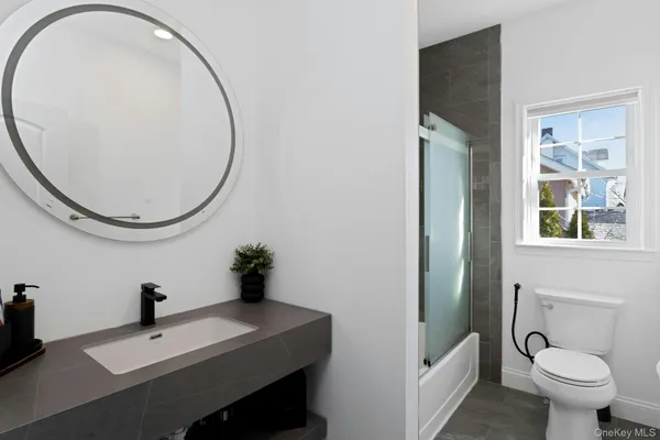 a bathroom with a sink a toilet and a mirror