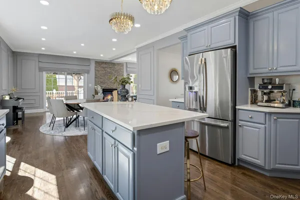 a kitchen with kitchen island a counter top space a sink stainless steel appliances and cabinets