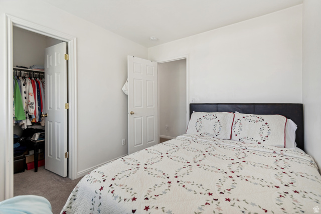 254 North 700 East Santaquin, UT 84655 - Photo 11 of 15 Bedroom featuring light neutral wall paint, carpet flooring, and a walk-in closet with a bi-fold door and interior shelving