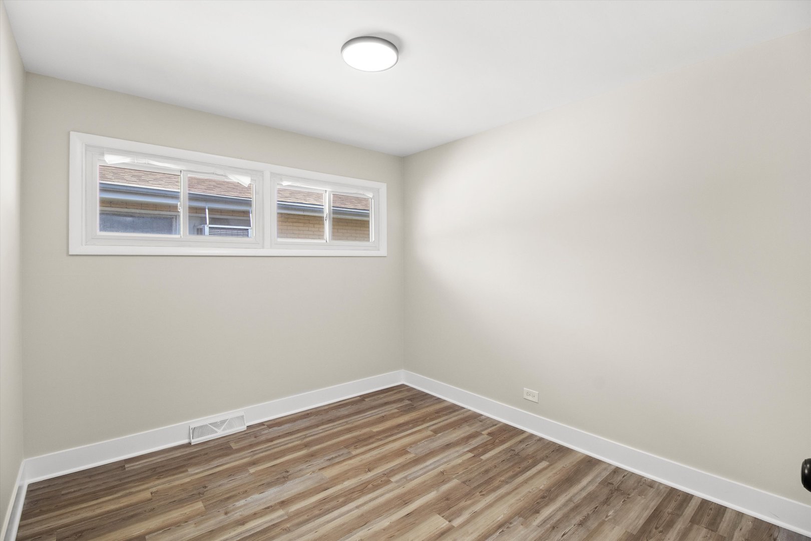 16460 Honore Avenue Markham, IL 60428 - Photo 26 of 38 an empty room with wooden floor and windows