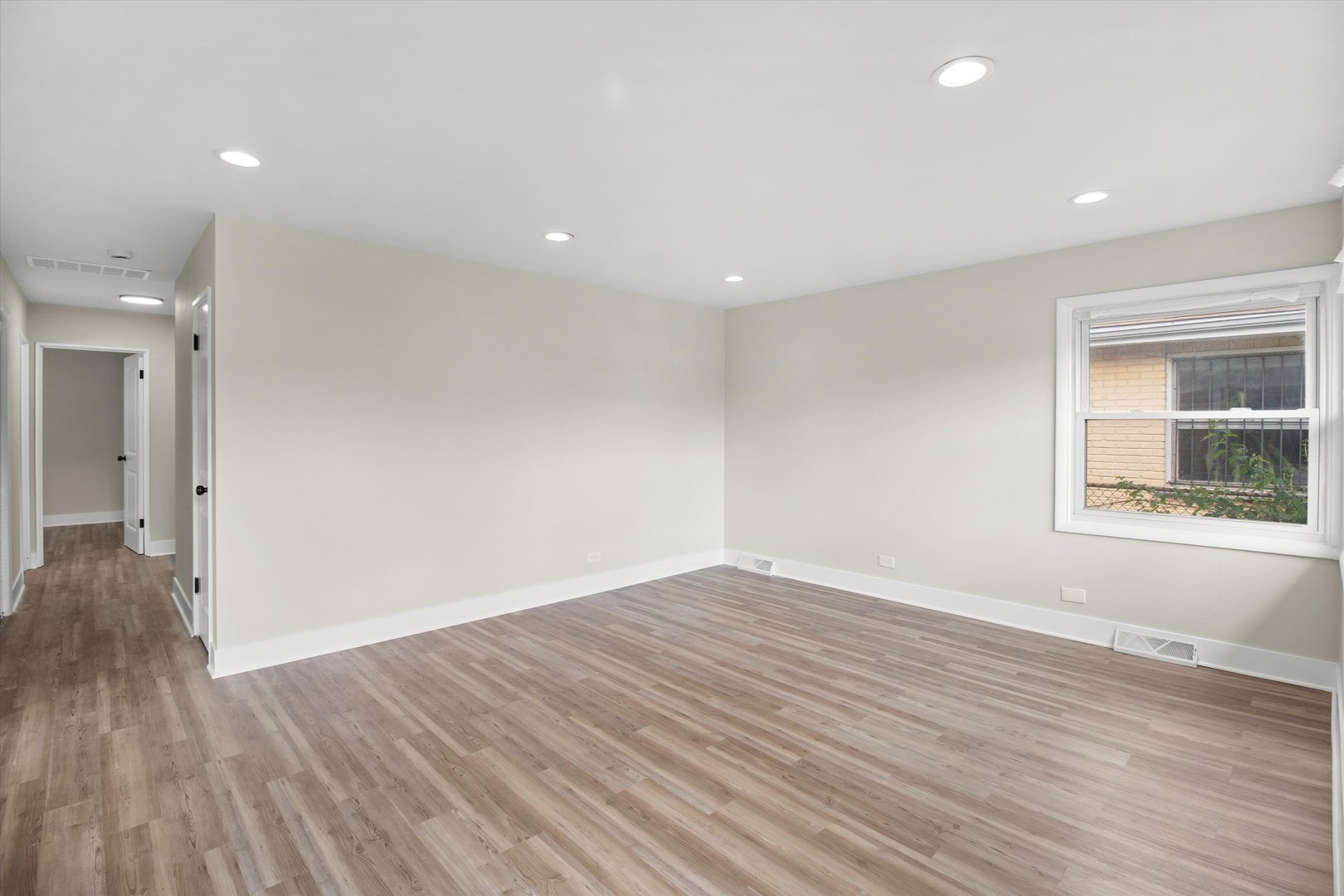 16460 Honore Avenue Markham, IL 60428 - Photo 4 of 38 an empty room with wooden floor and windows