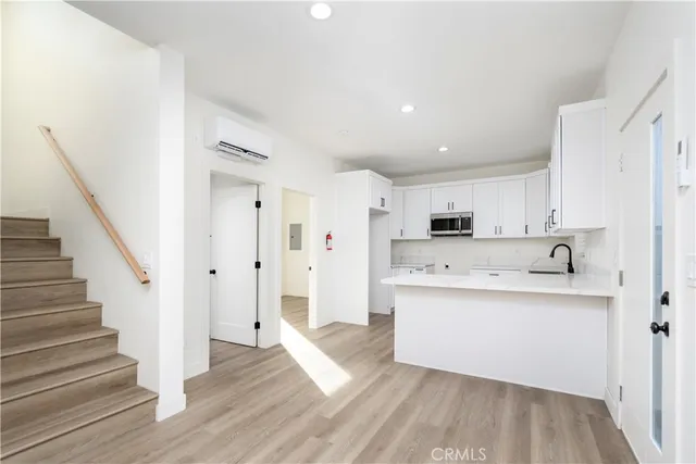 a view of a kitchen with sink and wooden floor