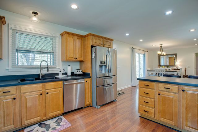 a kitchen with white cabinets and wooden floor
